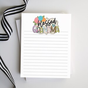 May include: A white notepad with lined paper and a decorative header that says "blessed grandma" with flowers and a heart.