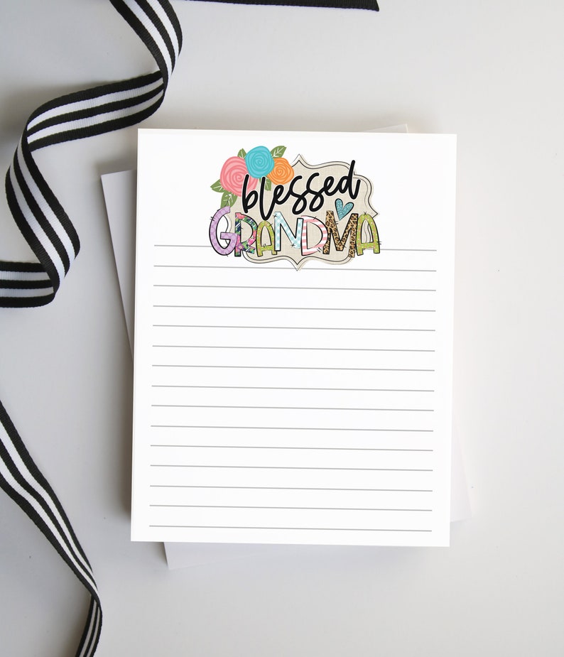 May include: A white notepad with lined paper and a decorative header that says "blessed grandma" with flowers and a heart.