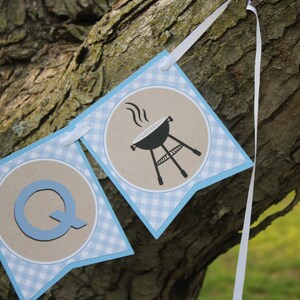 May include: A blue and white gingham banner with the letter Q and a black and white illustration of a grill with smoke coming from it.