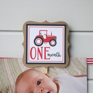 May include: A brown card with a black border and a red tractor illustration. The card says "ONE month" in red and black text.