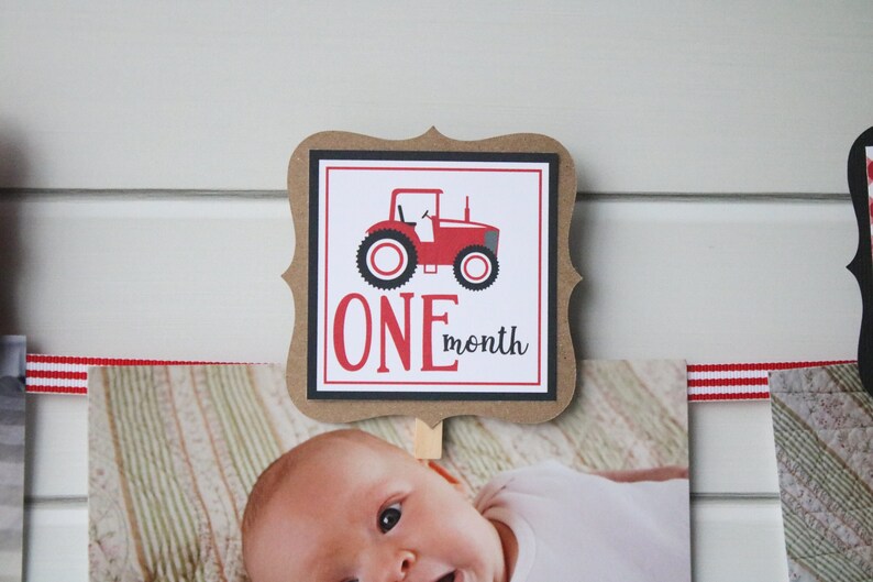 May include: A brown card with a black border and a red tractor illustration. The card says "ONE month" in red and black text.