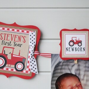 May include: Red and white tractor themed banner with the text "STEVEN'S First Year" and "NEWBORN". The banner is decorated with red and white gingham and polka dot ribbon.
