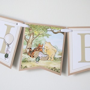 May include: A Winnie the Pooh themed banner with the letters "H" and "B" in a cream color with brown trim. The "H" features a small illustration of Piglet holding a balloon. The "B" features a beehive with bees flying around it. The middle section of the banner features a scene with Winnie the Pooh, Tigger, and Piglet.