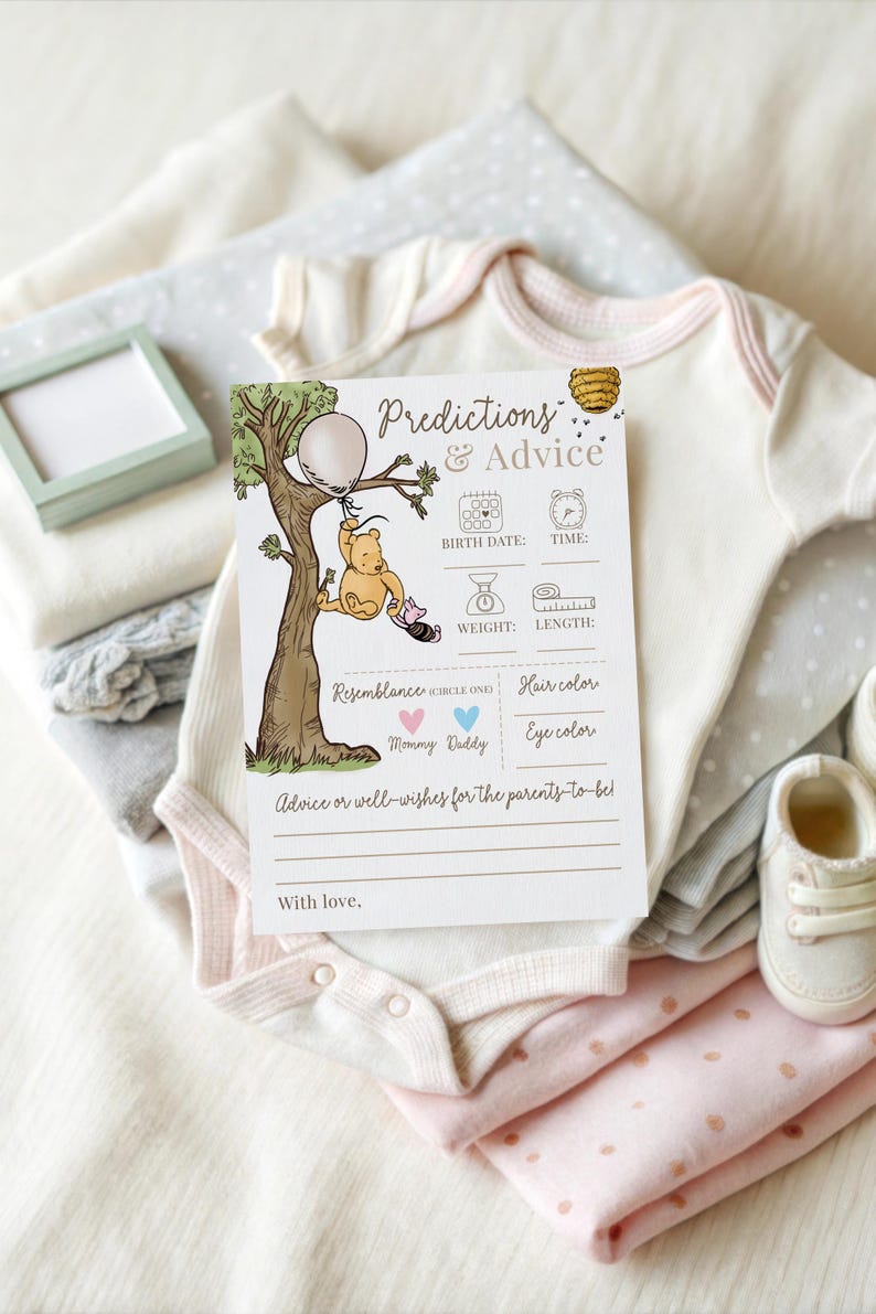 K&ouml;nnte beinhalten: Eine Babyparty-Spielkarte mit dem Text "Predictions & Advice" und einer Winnie-Puuh-Illustration. Die Karte ist von gefalteter Babykleidung in Wei&szlig;, Rosa und Grau sowie einem Paar Babyschuhe umgeben.