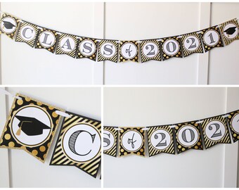 May include: Black and gold graduation banner with the text "Class of 2021". The banner has a black and white polka dot pattern and a black and gold striped pattern.
