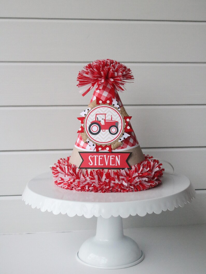 May include: Red and white checkered birthday party hat with a red tractor graphic and the name "STEVEN" on a banner.