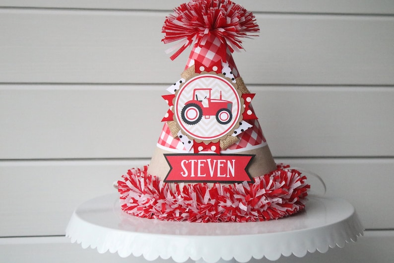 May include: Red and white checkered birthday party hat with a red tractor graphic and the name "STEVEN" on the front.