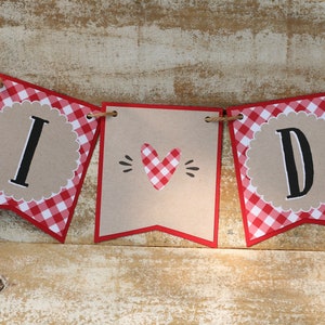 May include: A red and white gingham banner with the words "I DO" in black letters. The banner is strung with twine and has a heart-shaped cutout in the middle.