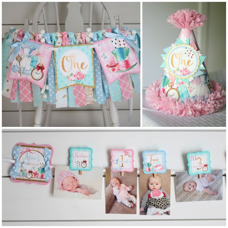May include: Alice in Wonderland themed first birthday party decorations. A banner with a pink and blue color scheme features images of Alice, the Mad Hatter, and the Queen of Hearts. The banner says "One" in gold letters. A pink and blue party hat with a gold crown and the word "One" is also included. A photo collage with images of a baby at different ages is shown with a pink and blue Alice in Wonderland theme.