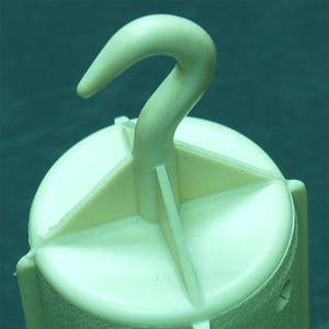May include: A white plastic hook with a cylindrical base. The base has four sections and several small holes. The hook is designed for hanging items.