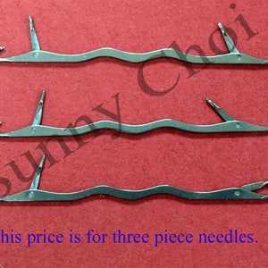 May include: Three silver crochet hooks with a curved shape and a pointed end. The text "This price is for three piece needles." is visible at the bottom of the image.