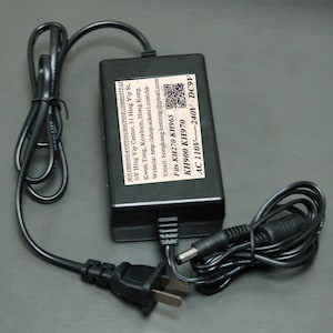 May include: Black power adapter with a black power cord and a US plug. The adapter has a label that reads "SUN CHEONG KNITTING MACHINE COMPANY LTD" and "Fits KH270 KH965 KH900 KH970 AC 110V~240V DC9V".