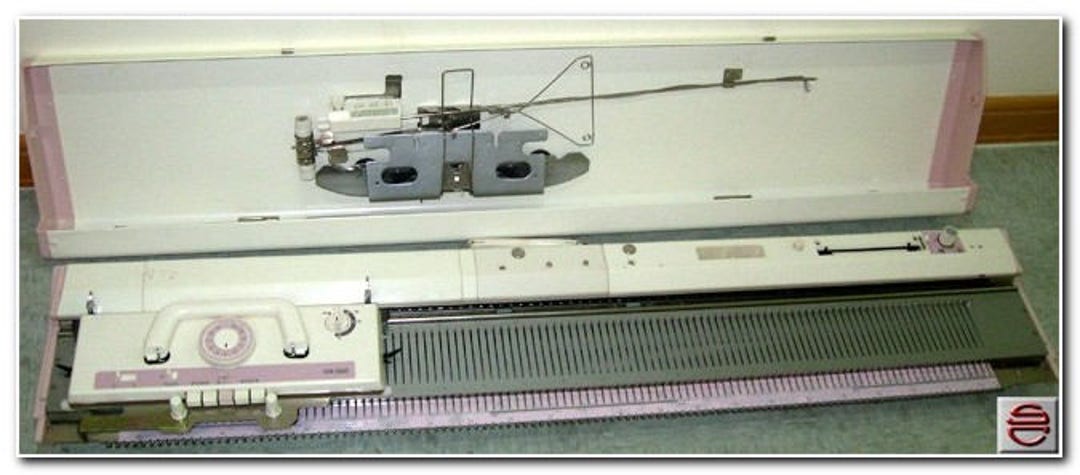 A Brother KH860 Knitting Machine with row counter, punch card, carriage and  attached sinker plate on a bed of knitting needles Stock Photo - Alamy