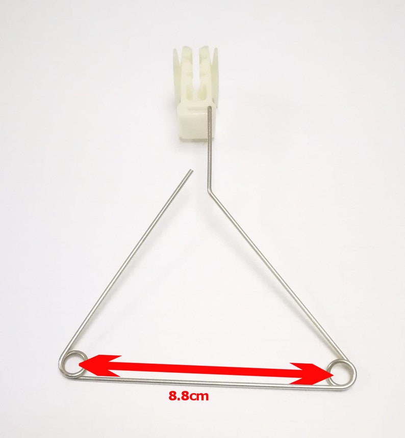 May include: A silver metal triangle with rounded ends and a white plastic piece at the top. The triangle measures 8.8 inches across.