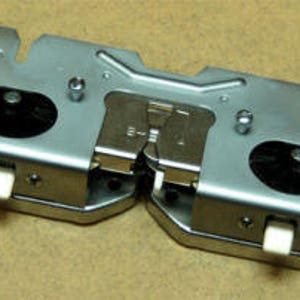 Può includere: Un meccanismo di chiusura in metallo argentato con due leve e una manopola in plastica nera. Il chiavistello è progettato per una porta o una finestra.