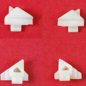 May include: Four white plastic corner protectors with a triangular shape and a small hole in the center.