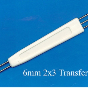 May include: White plastic tool with three metal needles, labelled "6mm 2x3 Transfer Tool". This tool is used for transferring beads or other small objects.