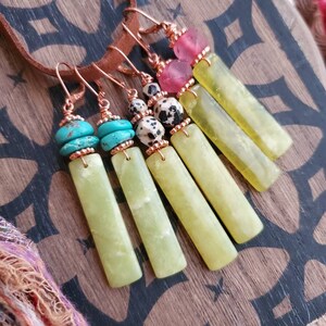 May include: Five pairs of dangle earrings with green jade stone pendants and various colored beads. The beads include turquoise, pink, and black and white dalmatian jasper.