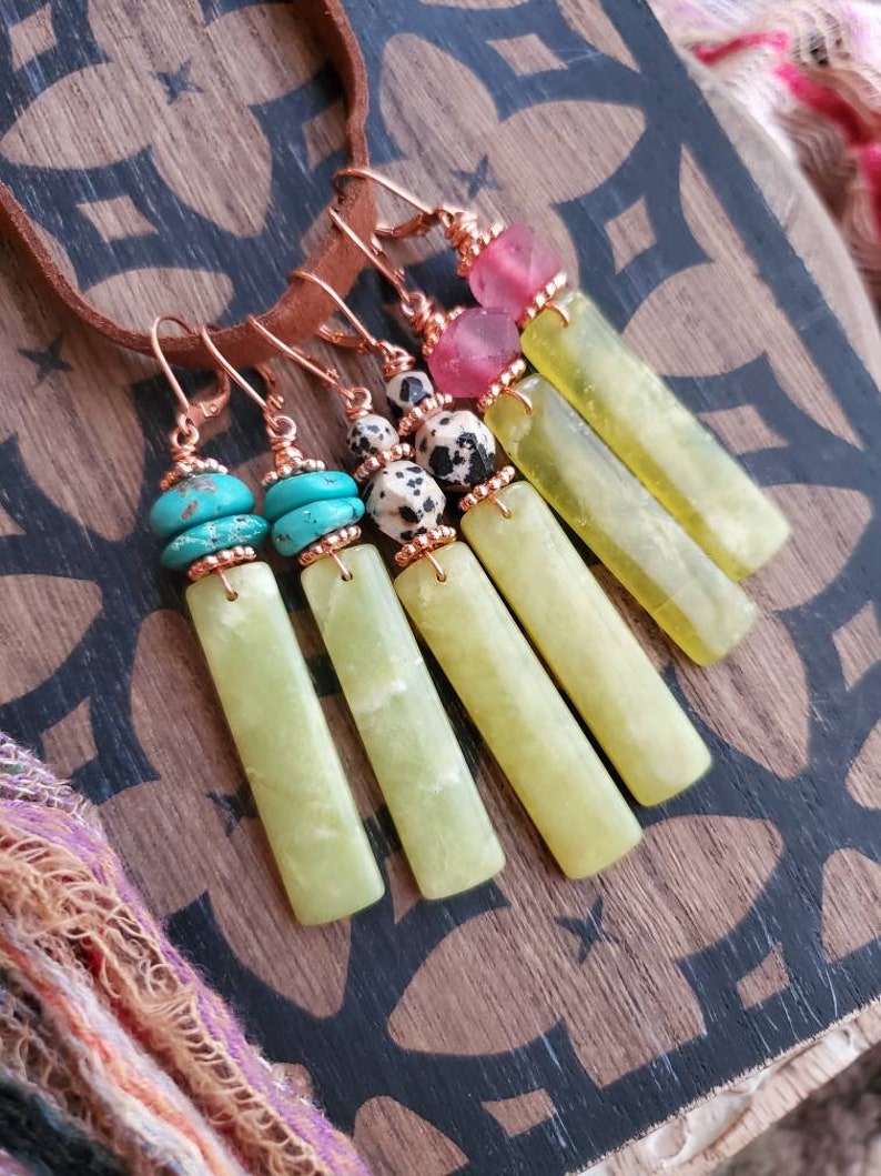 May include: Five pairs of dangle earrings with green jade stone pendants and various colored beads. The beads include turquoise, pink, and black and white dalmatian jasper.