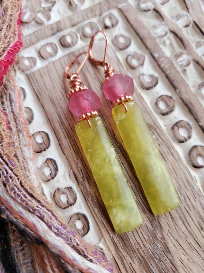 May include: A pair of dangle earrings with copper wire wrapped around green and yellow jade stone and pink glass beads.