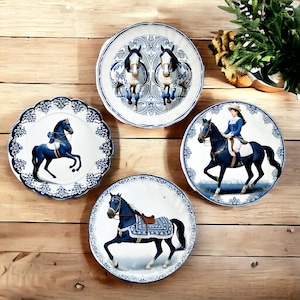 Könnte beinhalten: Vier blaue und weiße Keramikteller mit einem Pferdemotiv. Jeder Teller zeigt eine andere Pferdeszene, darunter ein Reiter, zwei nebeneinander stehende Pferde und ein einzelnes Pferd.