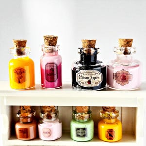 May include: A collection of eight small, glass potion bottles with cork stoppers. The bottles contain colorful liquids in shades of orange, pink, black, and green. Each bottle has a decorative label with text, such as "Hemlock Root" and "Poison Apples".