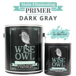 May include: Two dark gray paint cans with the text "WISE OWL Stain Eliminating PRIMER." The cans feature an illustration of an owl wearing a hat. The text "Stain Eliminating PRIMER DARK GRAY" is at the top.