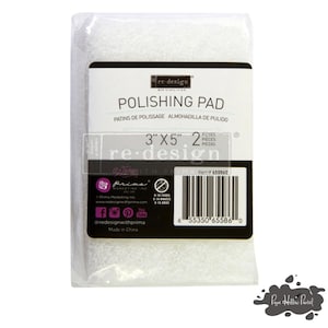 May include: A package containing two white polishing pads, each measuring 3" x 5". The label reads "POLISHING PAD" in English, French, and Spanish. The brand name "re-design" is visible on the label.