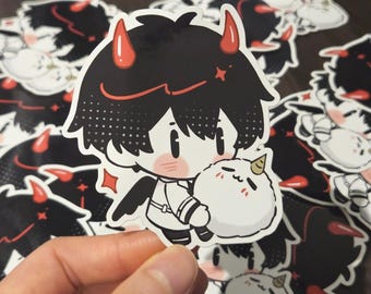 May include: A sticker featuring a cartoon character with black hair, red horns, and small black wings, holding a fluffy white creature. The sticker has a white border and is surrounded by similar stickers.