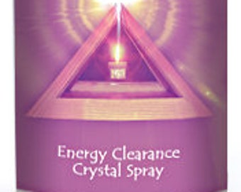 Puede incluir: Una botella de vidrio transparente con un pulverizador blanco. La botella tiene una etiqueta morada con el texto "A Touch of Light" y "Energy Clearance Crystal Spray".