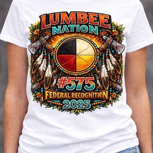 May include: White t-shirt featuring a colorful graphic design. The design includes the text "LUMBER NATION" in orange and black, a circular emblem with four colored sections, and the text "#575 FEDERAL RECOGNITION 2025".