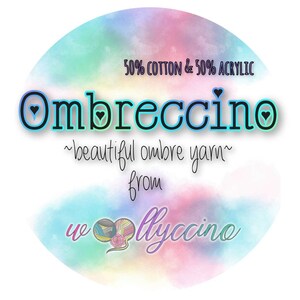 Op de afbeelding: Een ronde afbeelding met een aquarelachtergrond in tinten blauw, roze en groen. De tekst luidt "Ombreccino ~beautiful ombre yarn~ from wllyccino" met de woorden "50% cotton & 50% acrylic" bovenaan. Een garenbal-afbeelding staat onderaan.