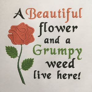 May include: A red rose with green leaves and the text "A Beautiful flower and a Grumpy weed live here!"