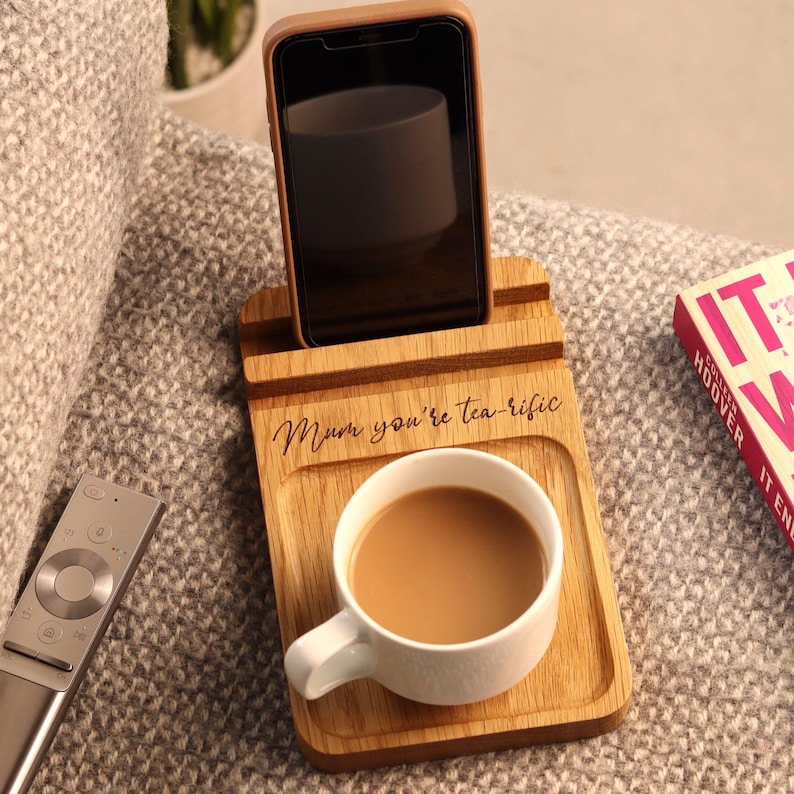 Może przedstawiać: Biały ceramiczny kubek z czarnym uchwytem i napisem "But First, Coffee" czarną, pogrubioną czcionką. Kubek stoi na białej powierzchni. Kubek ma około 10 cm wysokości.