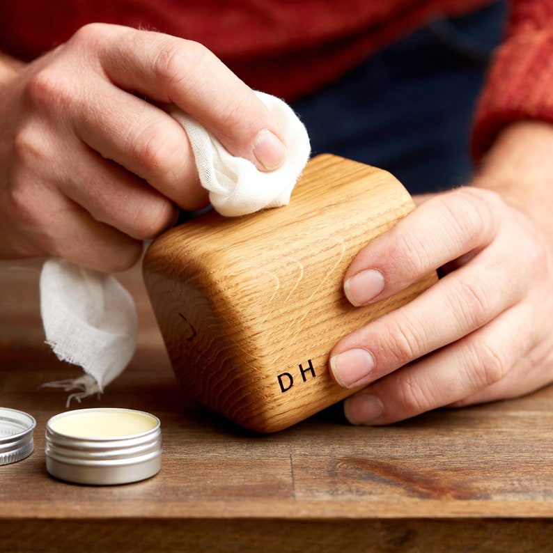 Wood butter being applied to solid oak whiskey tumbler