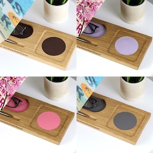 K&ouml;nnte beinhalten: Schreibtisch-Organizer aus Holz mit Stift, Brille und rundem Pad. Der Organizer tr&auml;gt den Text "Eat.Sleep.Read.Repeat." und ist in vier Farbvarianten erh&auml;ltlich: Braun, Lila, Rosa und Grau. Ein stilvolles und funktionales Schreibtischzubeh&ouml;r.