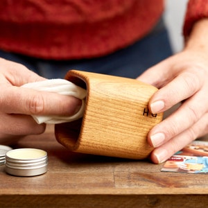 Wood butter being applied to solid oak whiskey tumbler