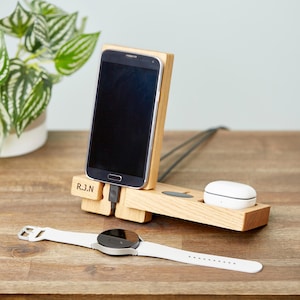 May include: A white ceramic mug with a black handle and the text "But First, Coffee" in a black, handwritten-style font. The mug is on a white surface.