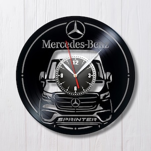 Puede incluir: Reloj de vinilo negro con la silueta de una furgoneta Mercedes-Benz Sprinter blanca con el logotipo de Mercedes-Benz y el texto "SPRINTER".