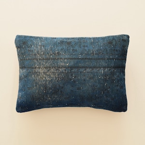 May include: A blue and white patterned cushion with a faded, vintage look.