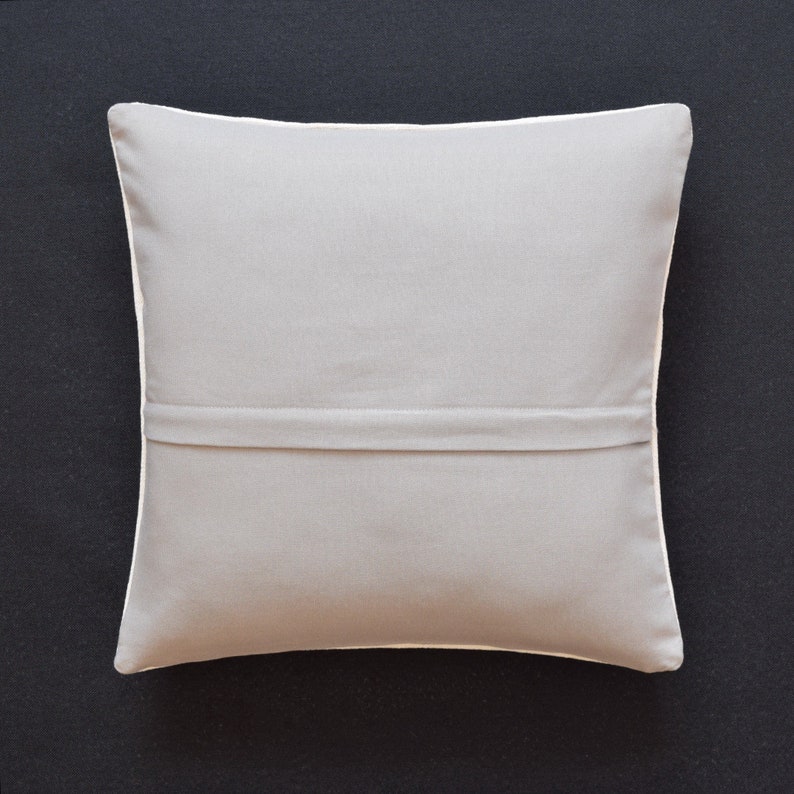May include: A plain gray throw pillow with a white border and a zipper closure on the back.