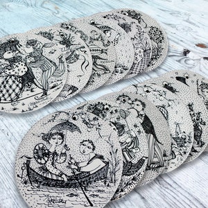 May include: A set of 12 black and white ceramic plates featuring whimsical illustrations of people and animals. The plates are round and have a white background with black designs.