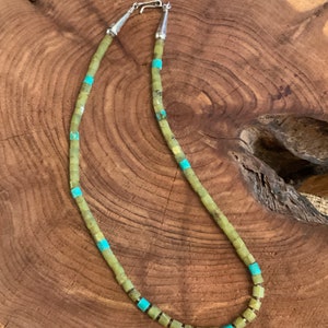 May include: A green and turquoise stone necklace with a silver clasp. The necklace is made of square-shaped beads.