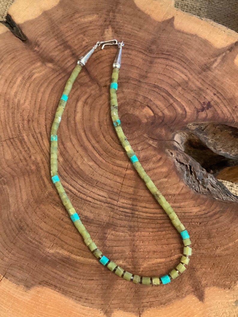 May include: A green and turquoise stone necklace with a silver clasp. The necklace is made of square-shaped beads.