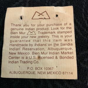 May include: A white tag with brown text that reads "Thank you for your purchase of a genuine Indian product. Look for the Bien Mur Trademark stamped inside your new jewelry. This is your guarantee that this item was Handmade by Indians on the Sandia Indian Reservation, Albuquerque, New Mexico. Bien Mur Indian Market Center is a U.S. Licensed & Bonded Indian Trading Co. P.O. BOX 10367 ALBUQUERQUE, NEW MEXICO 87114"