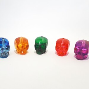 Peut inclure: Cinq perles en verre en forme de crâne de couleurs bleu, orange, vert, rouge et violet.