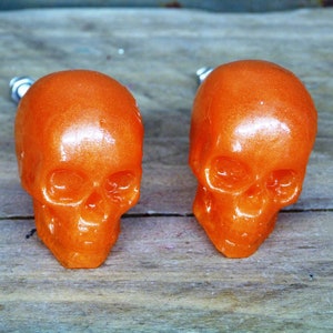May include: Two orange skull-shaped drawer pulls with a shiny finish.