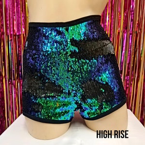 May include: High-waisted shorts covered in iridescent sequins, with a color gradient of green, blue, and black. The shorts have a black elastic waistband and trim. The text "HIGH RISE" is displayed at the bottom.