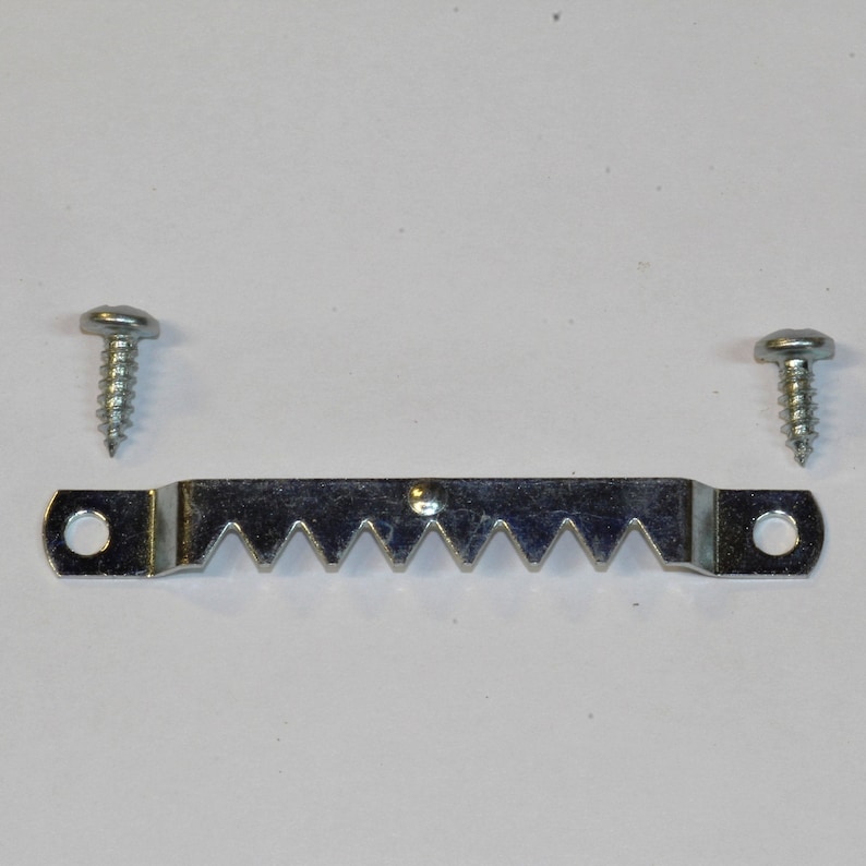 May include: A silver metal picture hanging hook with a serrated edge and two screws.
