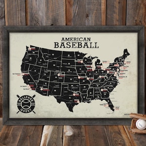 May include: A black and white map of the United States with red circles marking the location of baseball stadiums. The map is framed in a dark wood frame and has the text "AMERICAN BASEBALL" at the top. The text "BALLPARK QUEST" is at the bottom of the map.